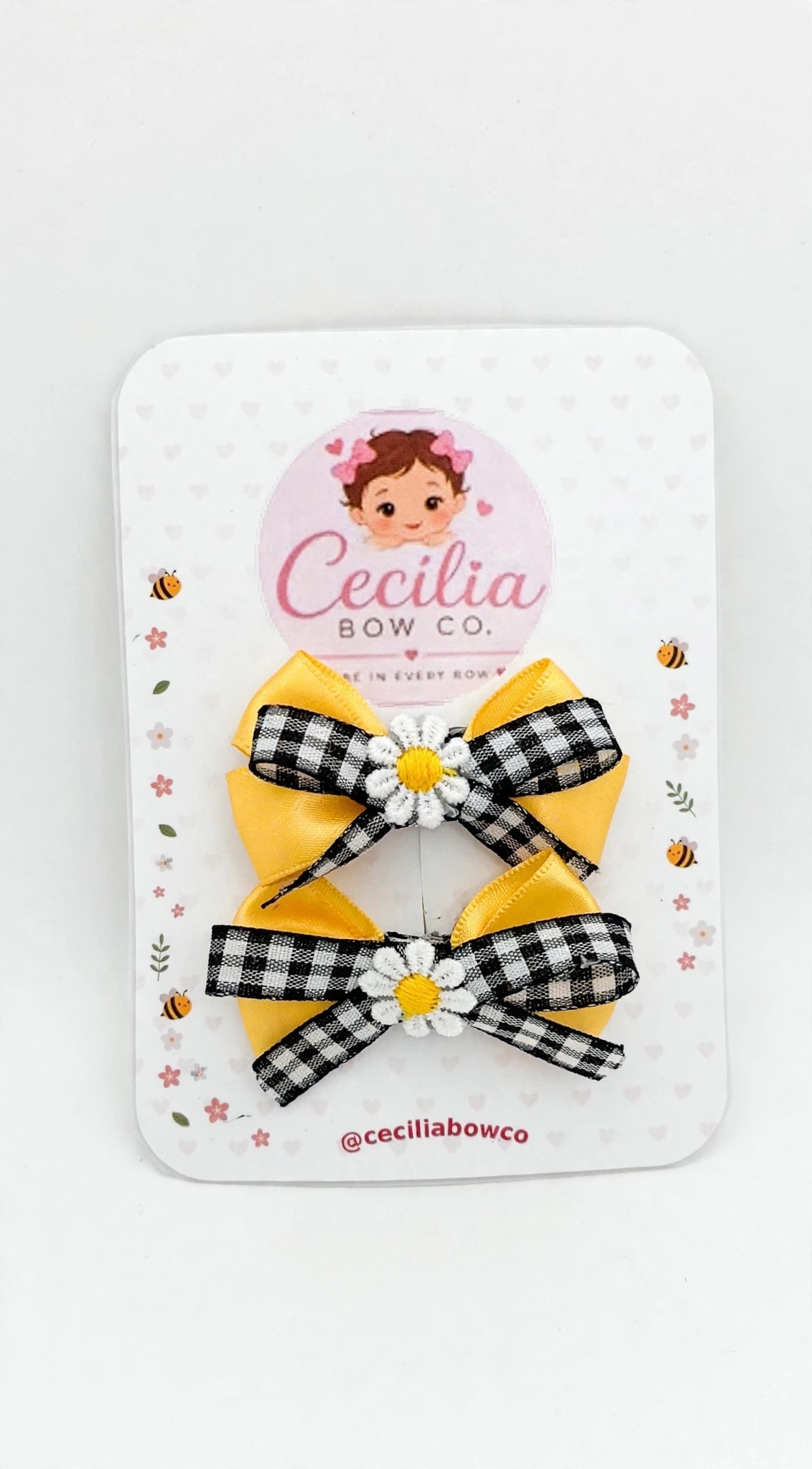 Pair of small yellow satin and gingham bows with white daisy centers